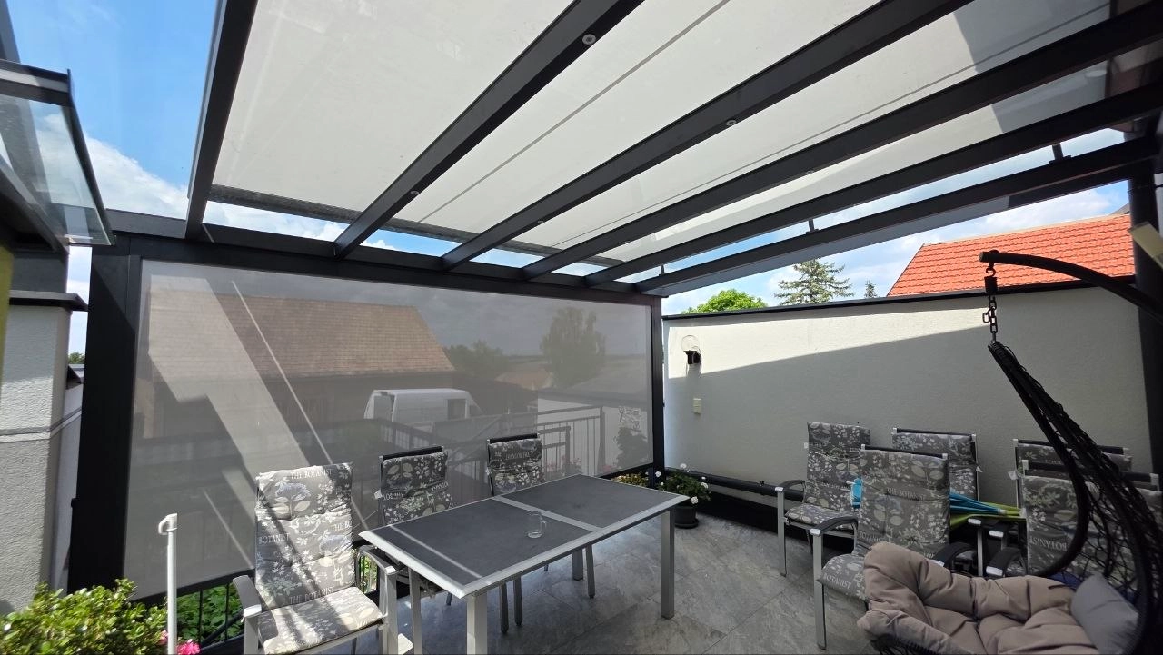 Überdachter Balkon mit Aluminiumprofilen und seitlicher Beschattung