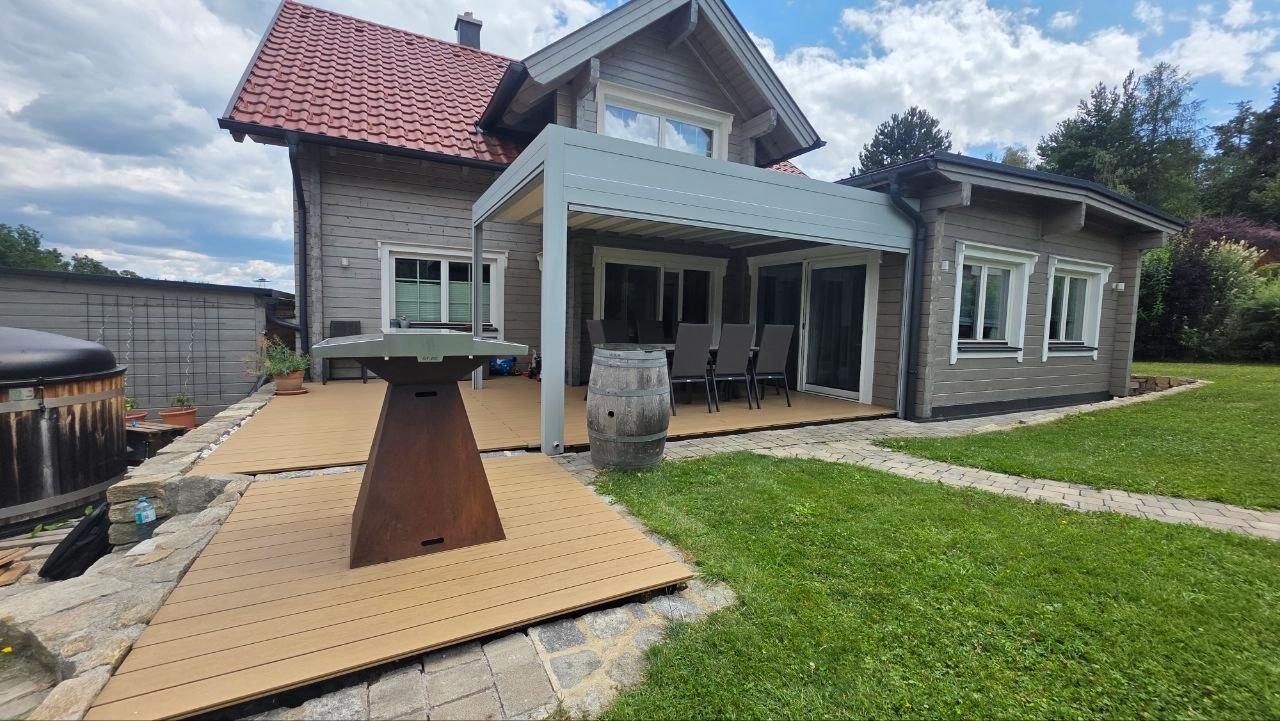 Helle Pergola über einer Holzterrasse am Wohnhaus